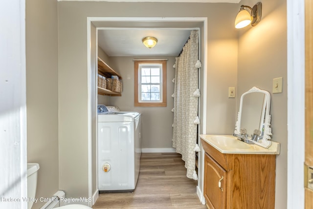 washroom with separate washer and dryer, sink, and light wood-type flooring