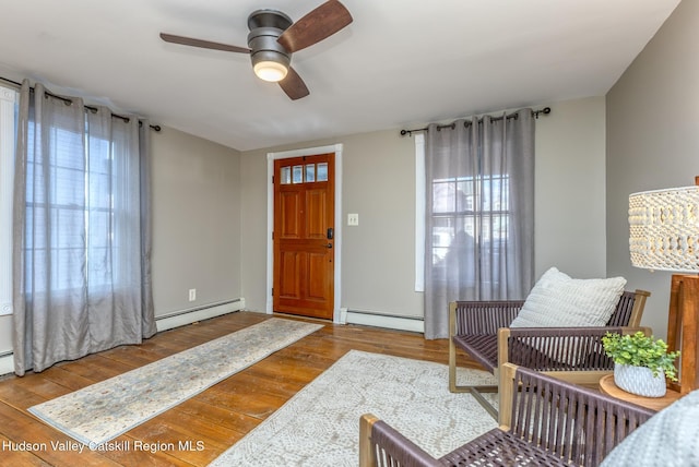 foyer with ceiling fan, a baseboard radiator, and light hardwood / wood-style flooring