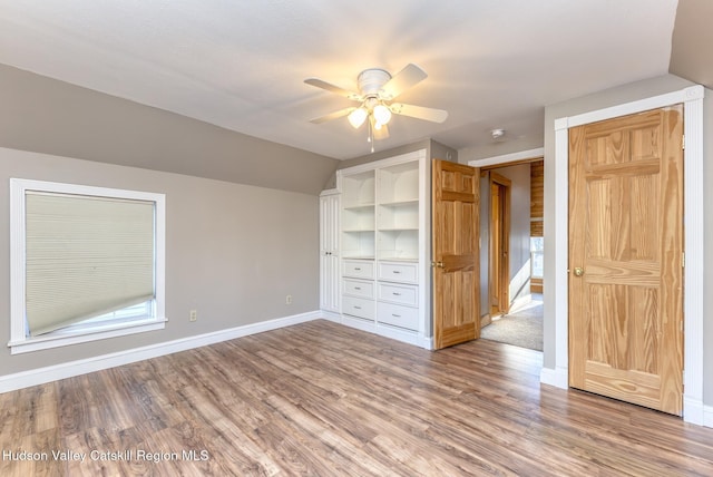 unfurnished bedroom with ceiling fan, vaulted ceiling, and wood-type flooring