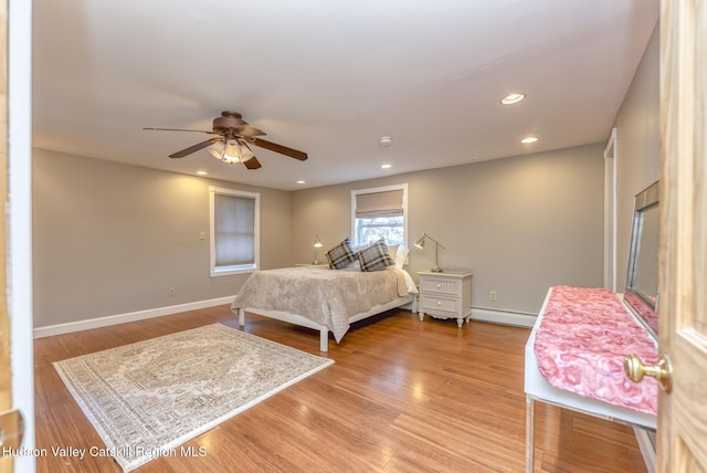 bedroom featuring a baseboard radiator, ceiling fan, and light wood-type flooring