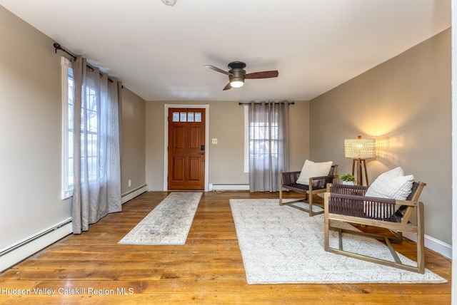 entryway featuring ceiling fan, wood-type flooring, and a baseboard heating unit