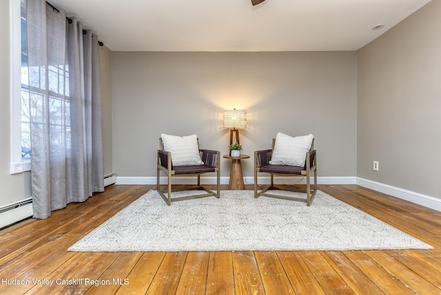 sitting room featuring a baseboard radiator and wood-type flooring