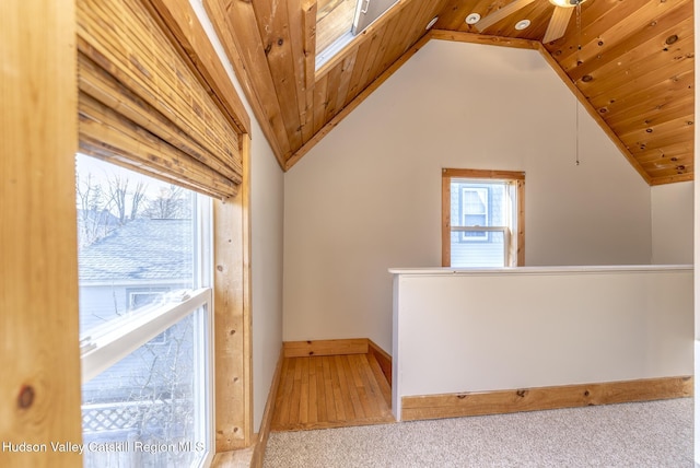 additional living space featuring wood ceiling, carpet floors, lofted ceiling with skylight, and ceiling fan