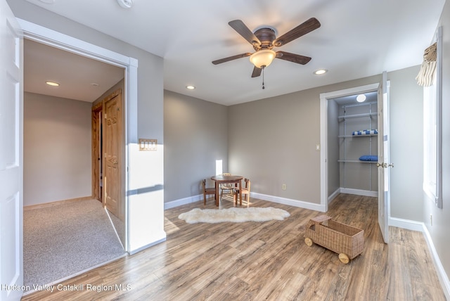 living area featuring hardwood / wood-style flooring and ceiling fan