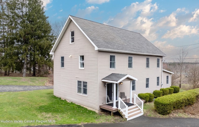 view of front of property with a front yard and roof with shingles