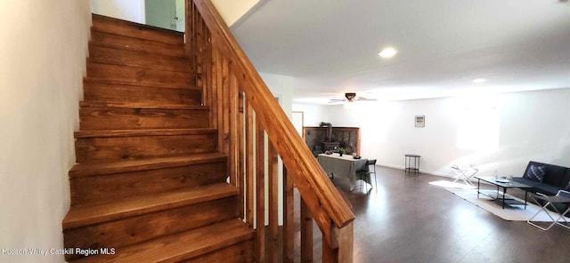 stairs with hardwood / wood-style floors and ceiling fan