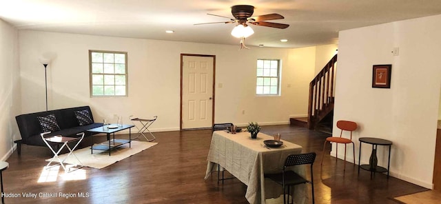 living room featuring ceiling fan and dark wood-type flooring