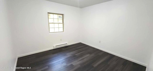 spare room with dark hardwood / wood-style flooring and baseboard heating