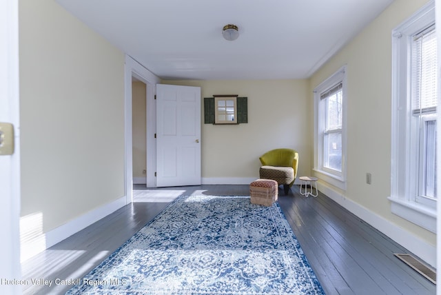 living area featuring dark hardwood / wood-style flooring and a healthy amount of sunlight