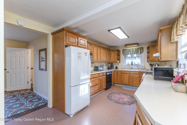 kitchen with black dishwasher, white fridge, and sink