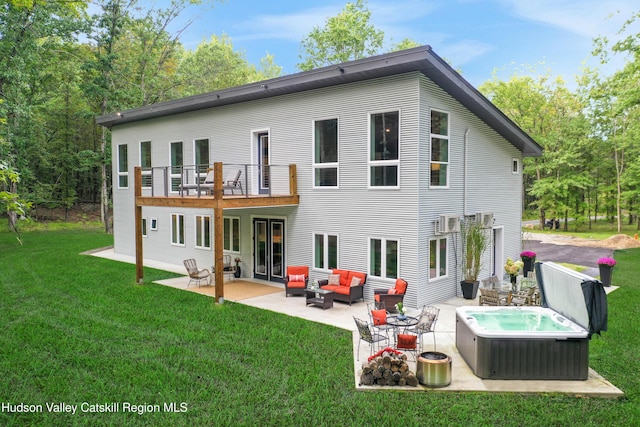 back of property featuring a balcony, a hot tub, a yard, outdoor lounge area, and a patio area