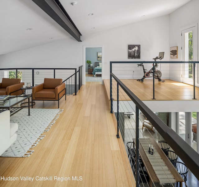 hall with lofted ceiling with beams and light hardwood / wood-style flooring