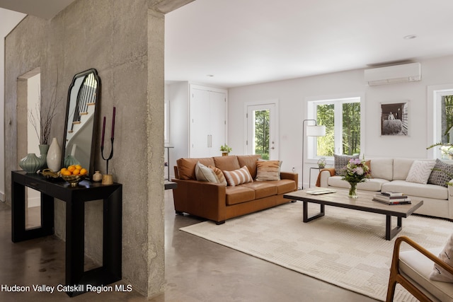 living room featuring an AC wall unit and concrete flooring