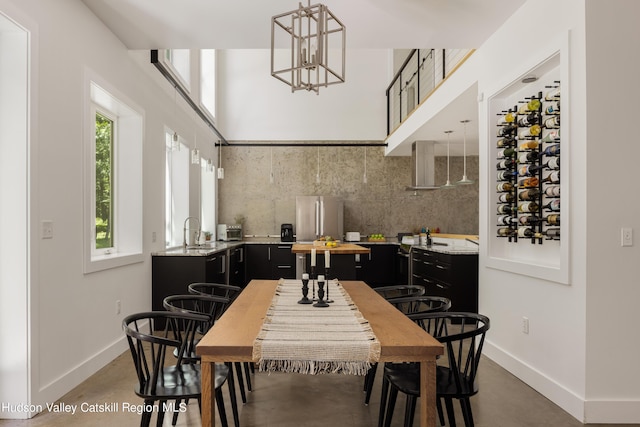 dining room with sink, concrete floors, and a notable chandelier