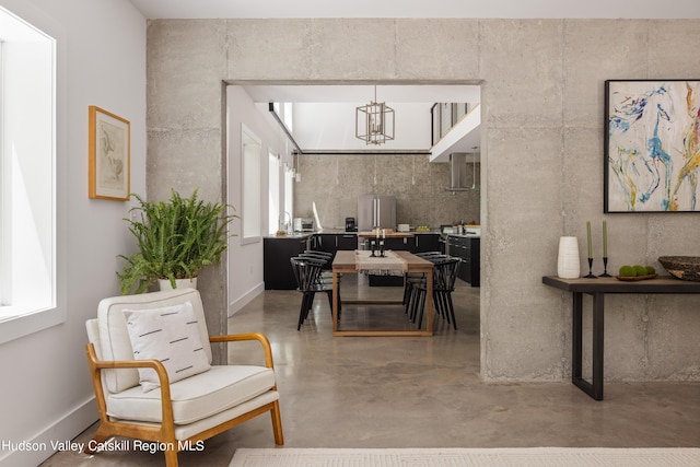 dining area featuring a chandelier and concrete floors