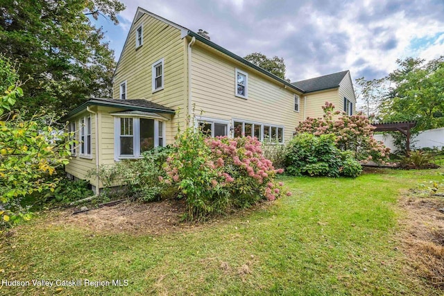 rear view of house featuring a lawn