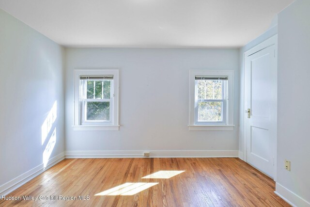 unfurnished room with plenty of natural light and light hardwood / wood-style floors