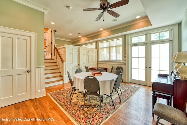 dining space with ceiling fan, light wood-type flooring, crown molding, and french doors
