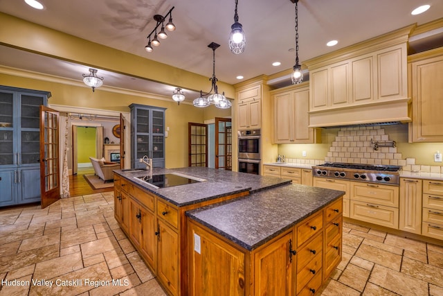 kitchen with french doors, hanging light fixtures, an island with sink, appliances with stainless steel finishes, and tasteful backsplash