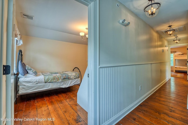 bedroom featuring hardwood / wood-style floors and a chandelier