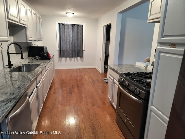 kitchen with stainless steel appliances, white cabinetry, dark hardwood / wood-style floors, and sink