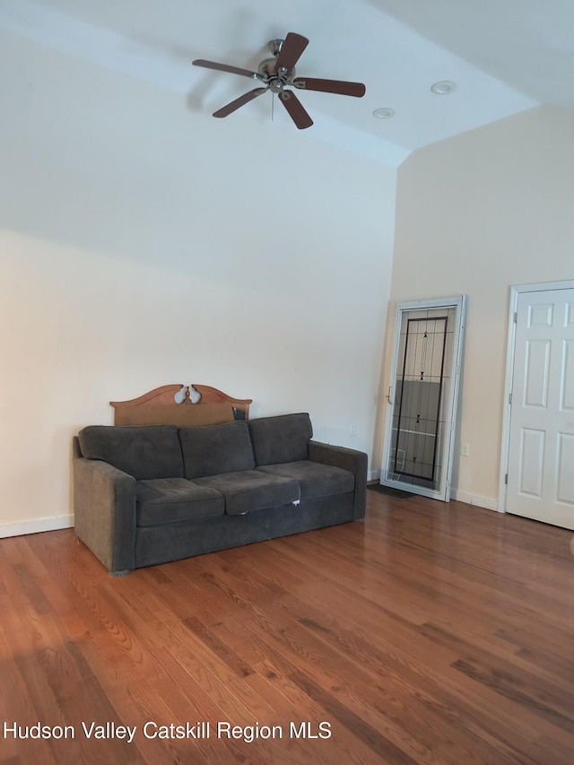 living room featuring ceiling fan, hardwood / wood-style floors, and a high ceiling