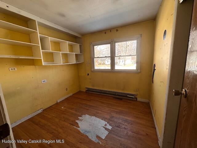 interior space with a baseboard radiator and hardwood / wood-style floors