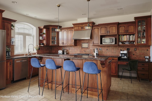 kitchen with under cabinet range hood, stainless steel appliances, a center island, open shelves, and glass insert cabinets