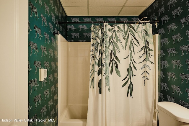 full bath with toilet, shower / tub combo, a paneled ceiling, and wallpapered walls