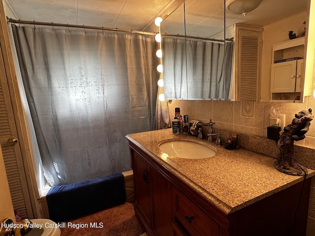 bathroom with vanity, decorative backsplash, and shower / bathtub combination with curtain