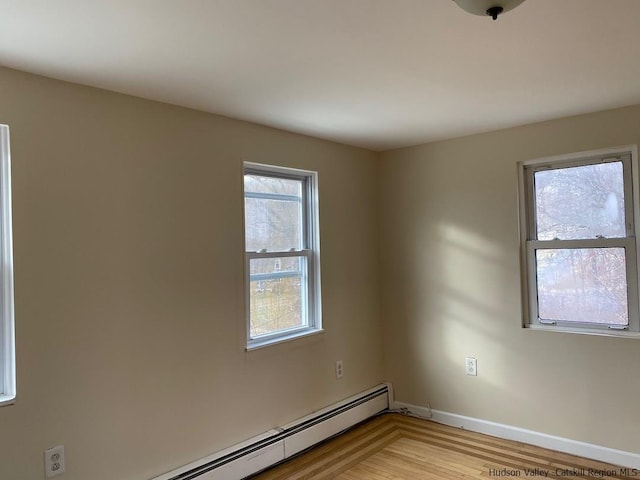 unfurnished room with a baseboard radiator and light hardwood / wood-style flooring