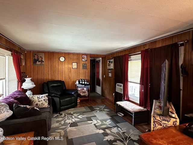 living room with wood walls, a healthy amount of sunlight, and dark hardwood / wood-style flooring