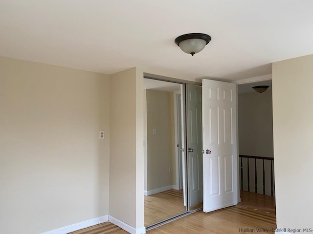 unfurnished bedroom featuring a closet and light wood-type flooring