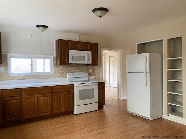 kitchen featuring decorative backsplash, white appliances, and light hardwood / wood-style flooring