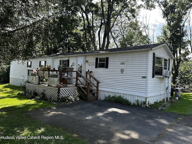 view of front of home with a deck and a front yard