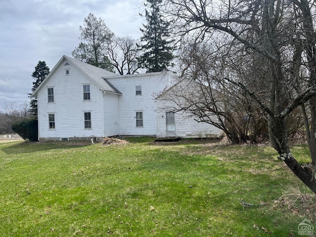 rear view of property with a yard and a shingled roof