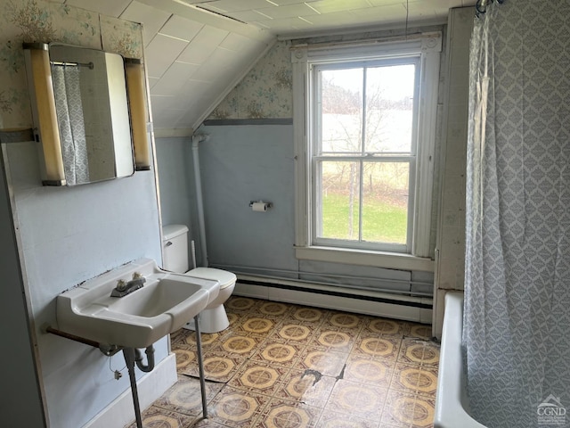 bathroom with wallpapered walls, baseboard heating, healthy amount of natural light, toilet, and lofted ceiling