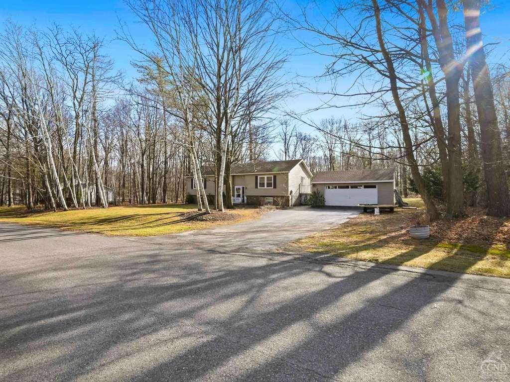view of front of house with driveway, a front lawn, and an outdoor structure