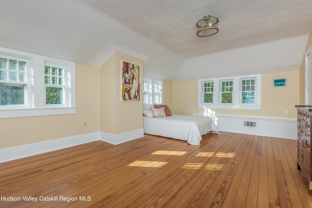 unfurnished bedroom featuring hardwood / wood-style flooring and vaulted ceiling