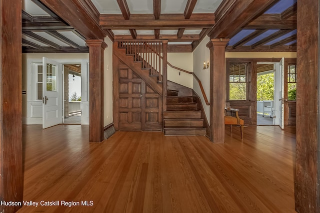 interior space with hardwood / wood-style floors, ornate columns, beamed ceiling, and coffered ceiling