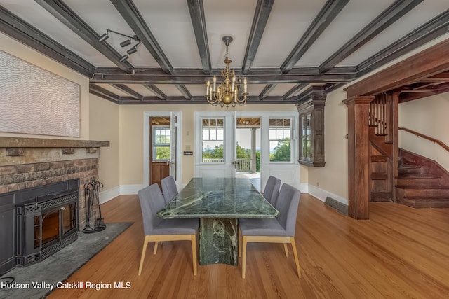 dining space with beamed ceiling, a notable chandelier, and wood-type flooring