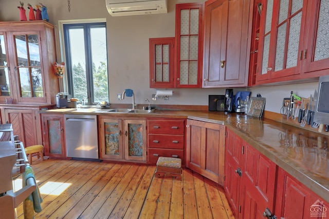 380 Main St, New Baltimore, NY 12124 - kitchen with stainless steel dishwasher, an AC wall unit, a sink, light wood-style floors, and glass insert cabinets