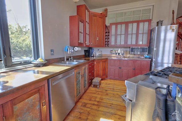380 Main St, New Baltimore, NY 12124 - kitchen featuring stainless steel appliances, a sink, light wood-style flooring, and glass insert cabinets