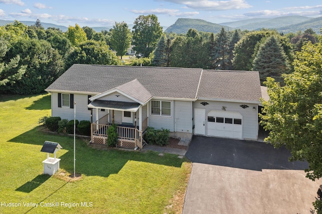 109 Union St, Middleburgh, NY 12122 - view of front facade featuring a garage, covered porch, asphalt driveway, a front lawn, and a shingled roof