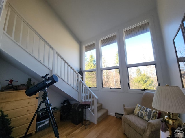 56 Highlands Dr Unit F-5, Hunter, NY 12442 - living area featuring stairs, baseboard heating, wood finished floors, healthy amount of natural light, and a towering ceiling