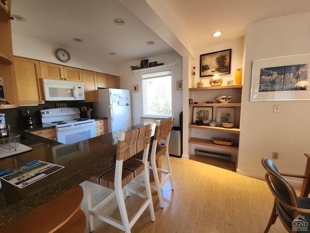 56 Highlands Dr Unit F-5, Hunter, NY 12442 - kitchen with white appliances, dark countertops, light wood finished floors, recessed lighting, and a peninsula