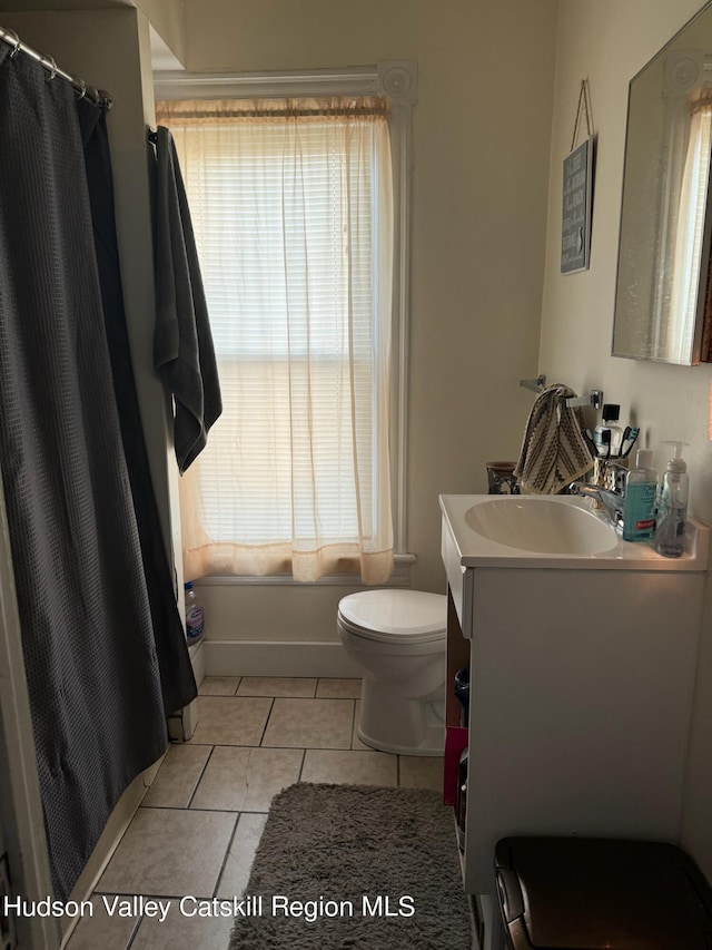 bathroom featuring tile patterned floors, vanity, curtained shower, and toilet