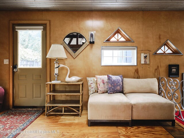 sitting room with wood-type flooring, plenty of natural light, and wooden ceiling