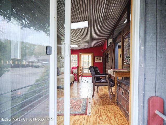 interior space with hardwood / wood-style floors and vaulted ceiling