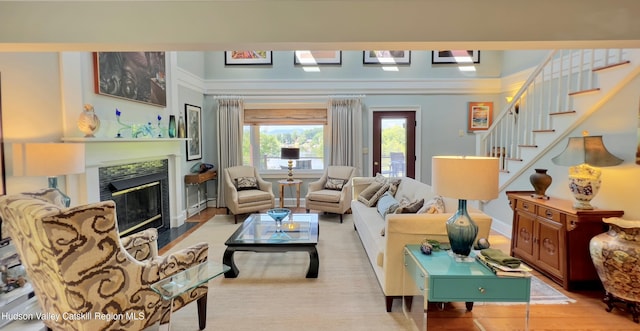 50 Manhattoes Dr, Athens, NY 12015 - living room featuring a fireplace with flush hearth, wood finished floors, stairway, and ornamental molding
